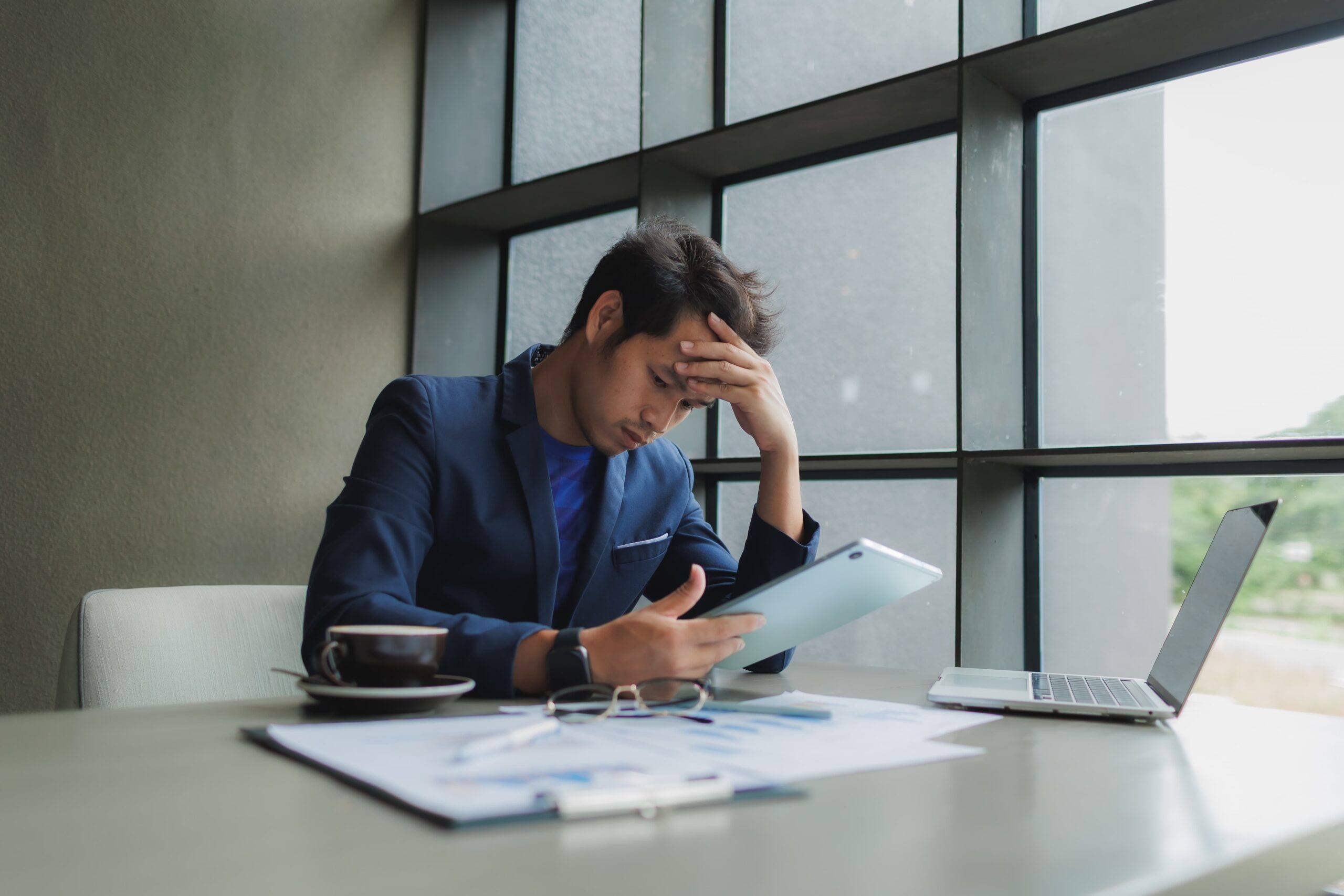 Professional experiencing emotional stress from deadlines, symbolizing a workplace trigger after recovery